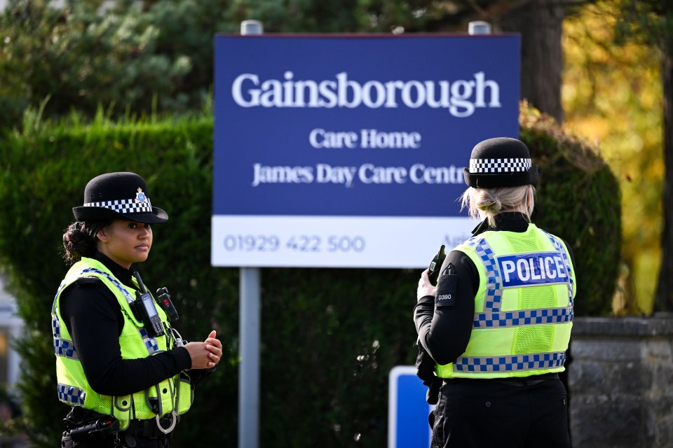 two police officers standing in front of a gainsborough sign