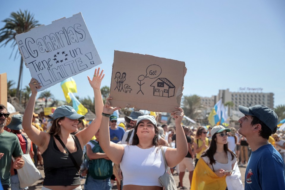 a woman holds up a sign that says canarias tengo un limite