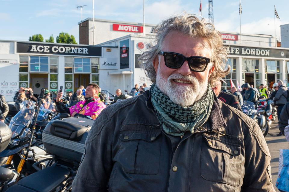 a man stands in front of a building that says ace corner