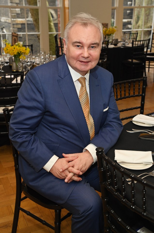 a man in a suit and tie sits at a table