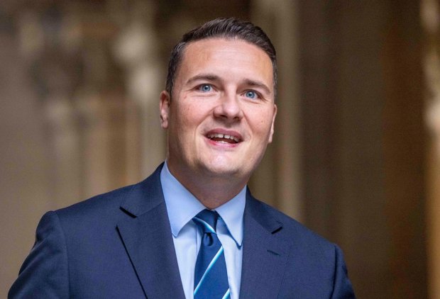 a man in a suit and tie is smiling and looking up