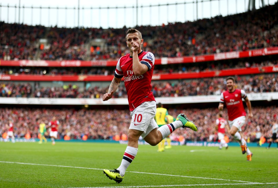 a soccer player wearing a fly emirates jersey celebrates his goal