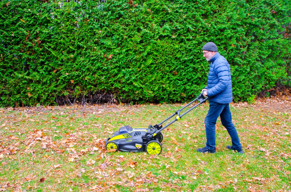 a man is pushing a lawn mower that says ryobi on it