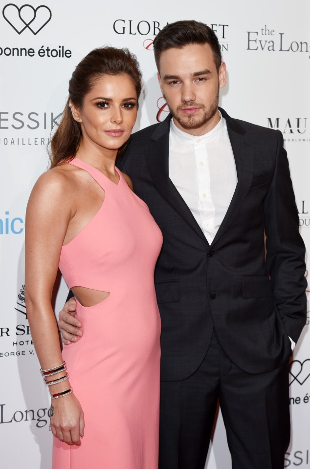 a man in a suit and a woman in a pink dress pose for a photo