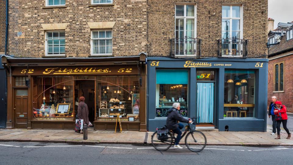 a man riding a bike in front of a store called fitzbullies