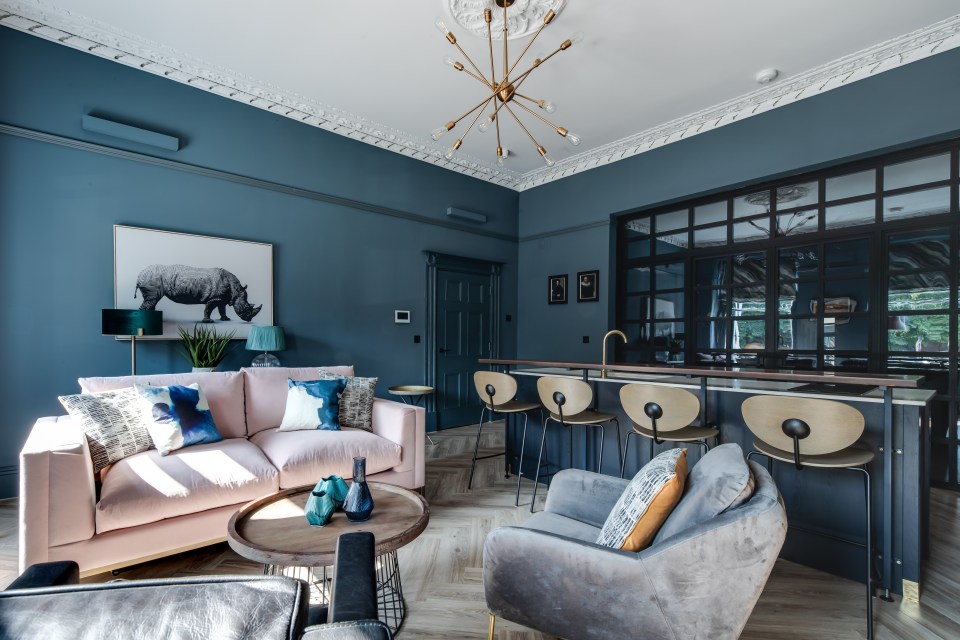 a living room with a pink couch and a picture of a rhino on the wall