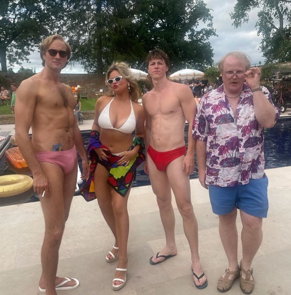 a group of people posing for a picture in front of a pool