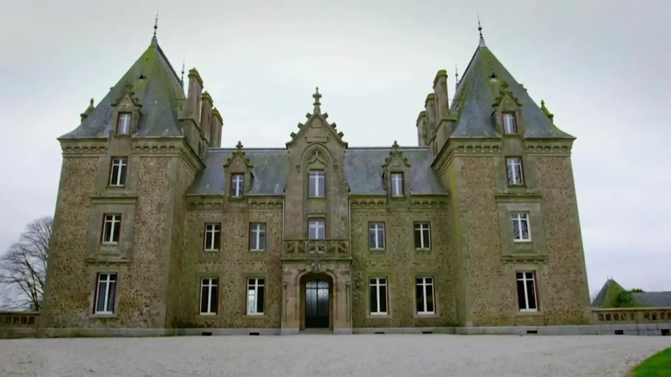 a large stone castle with a cross on the top of it