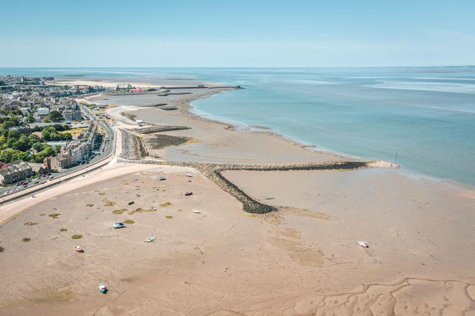 an aerial view of a beach with boats in the water