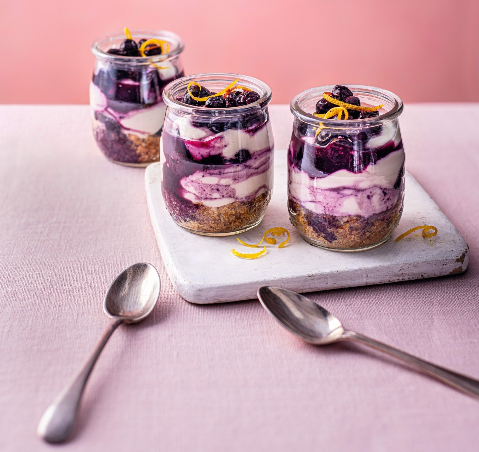 three jars of dessert with spoons on a table