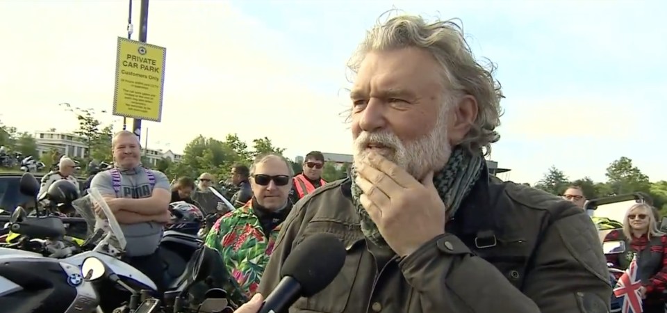 a man is being interviewed in front of a sign that says private car park