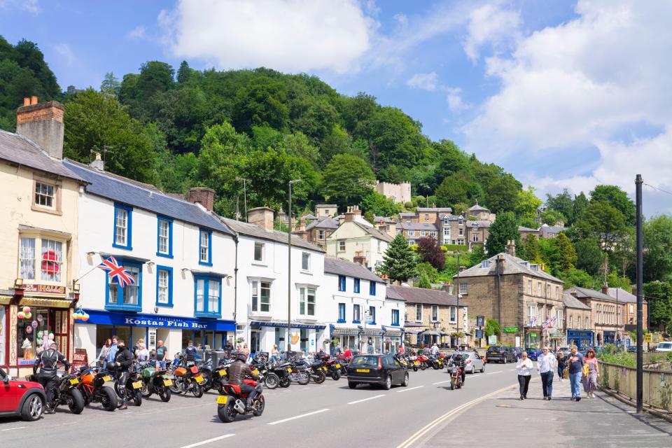 a row of motorcycles are parked in front of a scottish fish bar