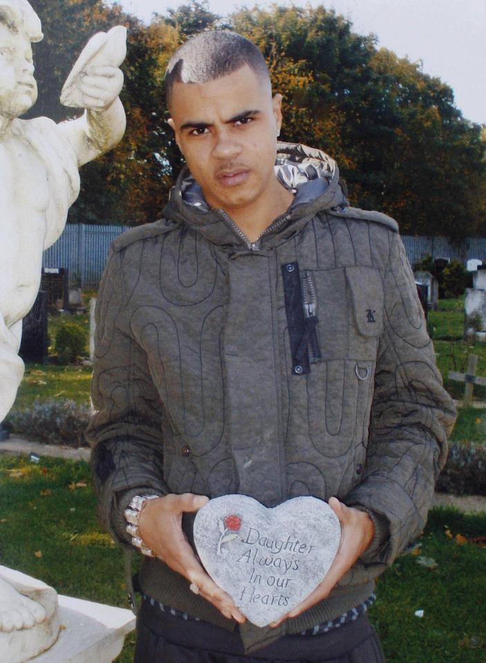 a young man holds a heart shaped stone that says daughter always in our hearts