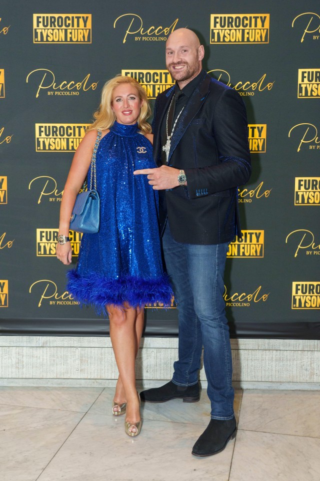 a man and a woman pose in front of a wall that says eurocity tyson fury