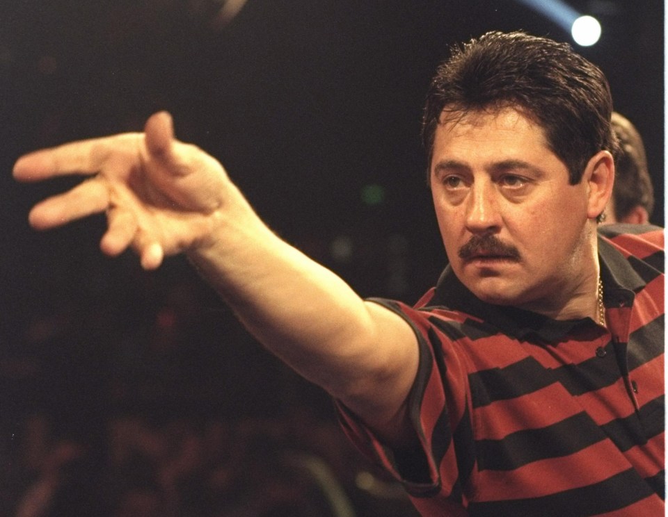 a man in a striped shirt is throwing a dart in the air