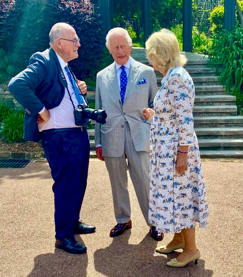 a man holding a camera talks to two men and a woman