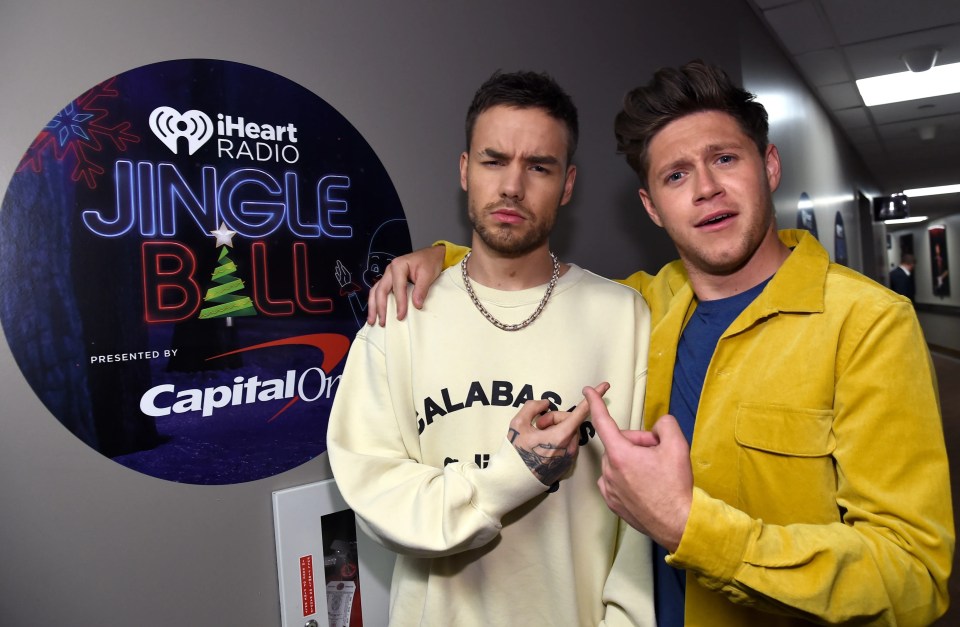 two men standing in front of a sign that says jingle ball