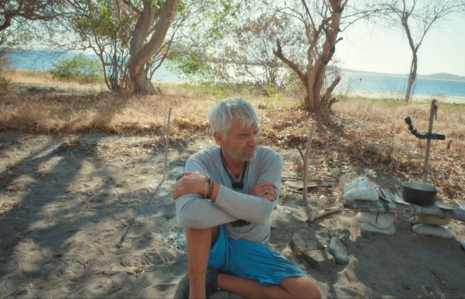 a man sitting on the ground with his arms crossed