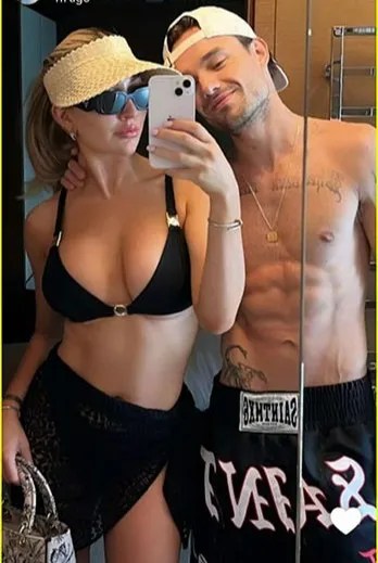 a man and a woman are taking a selfie in front of a mirror .