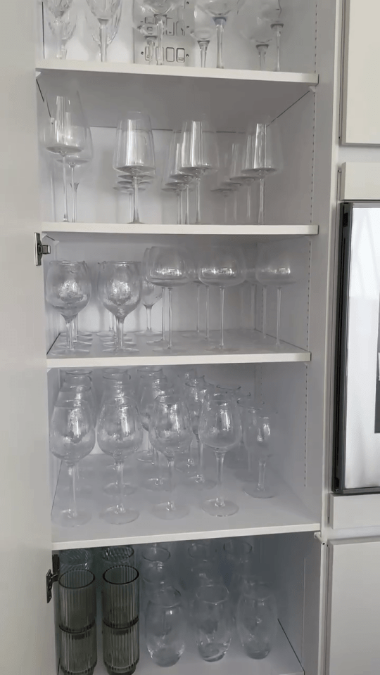 a cabinet filled with wine glasses and glasses stacked on top of each other