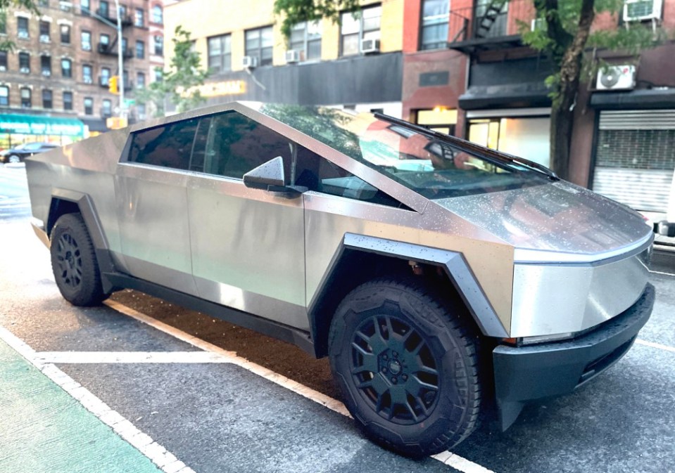 The Tesla Cybertruck parked on a New York City street after a rainstorm. This high-end vehicle is known for its durability and ruggedness, featuring shatter-resistant glass, a strong towing capacity, lockable storage, and a light bar for illuminating long distances. Inside, the Cybertruck is equipped with advanced technology, including a touchscreen interface.. (Photo by: Deb Cohn-Orbach/UCG/Universal Images Group via Getty Images)