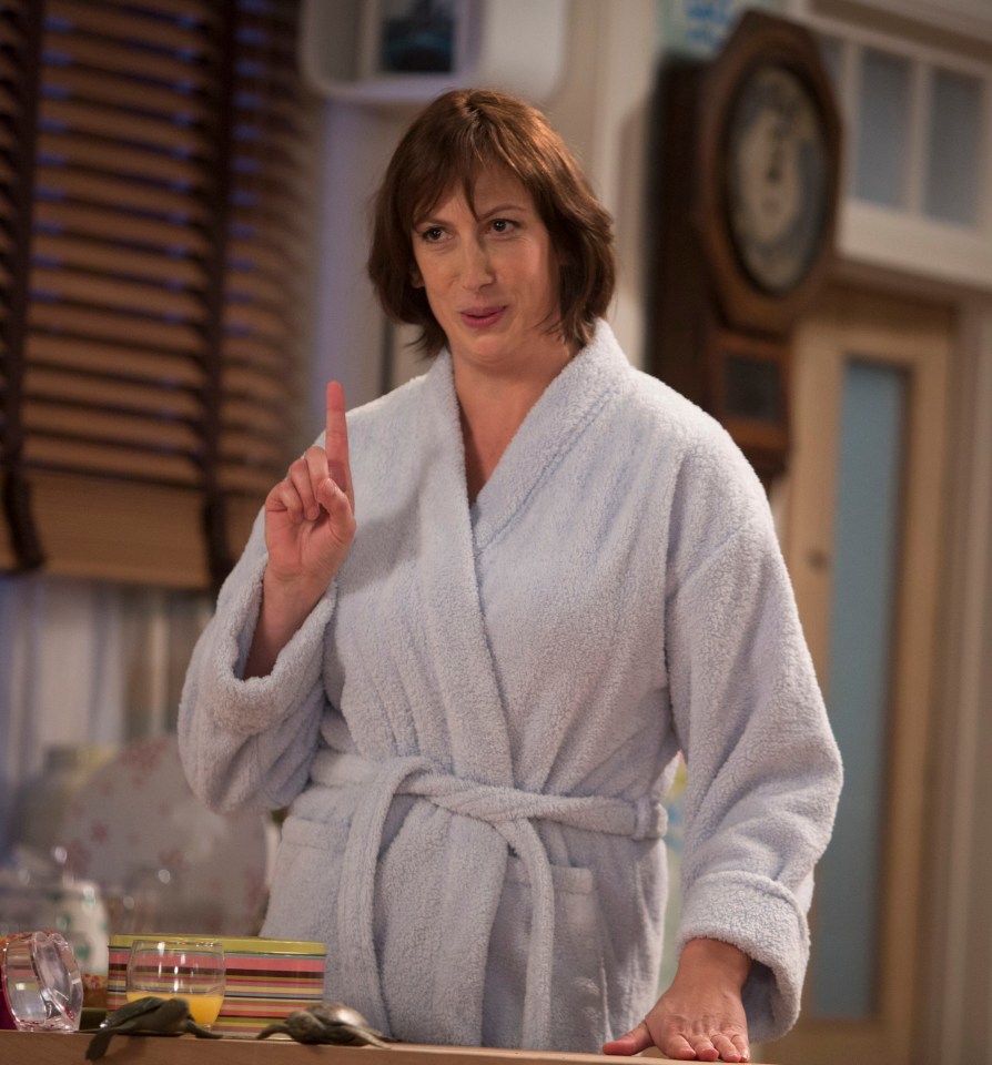 a woman in a bathrobe is pointing at something