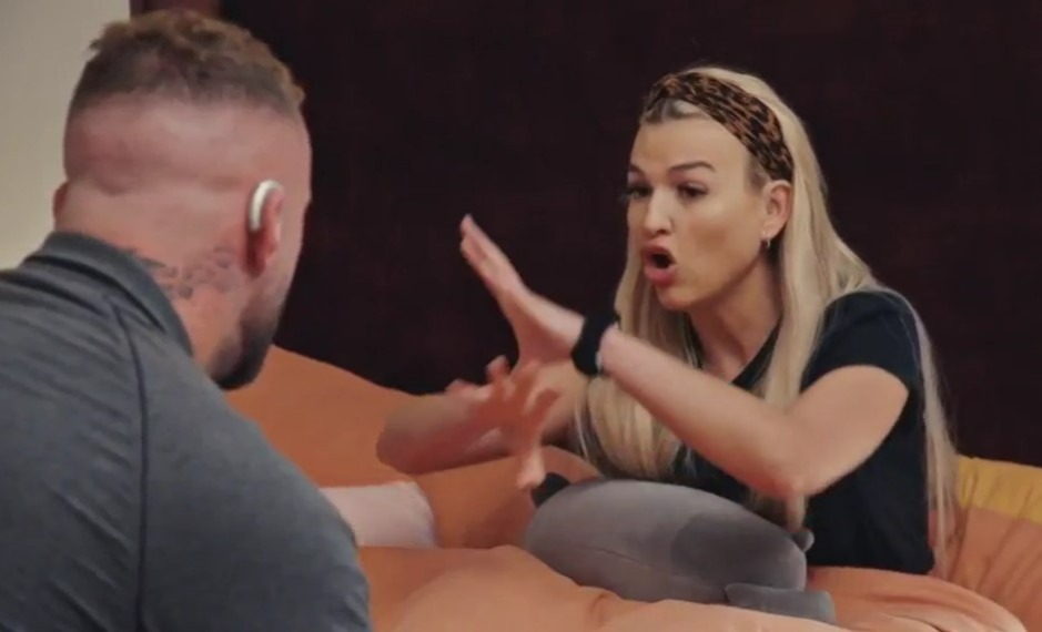 a man and a woman are sitting on a couch and the woman is wearing a leopard print headband