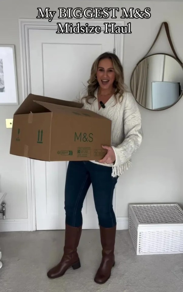 a woman holding a cardboard box that says m & s on it