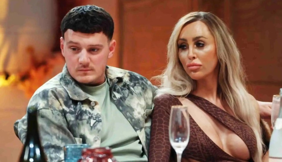 a man and a woman sit at a table with wine glasses