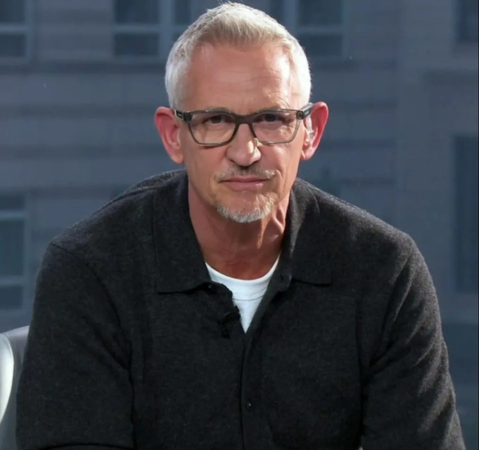 a man wearing glasses and a grey shirt looks at the camera