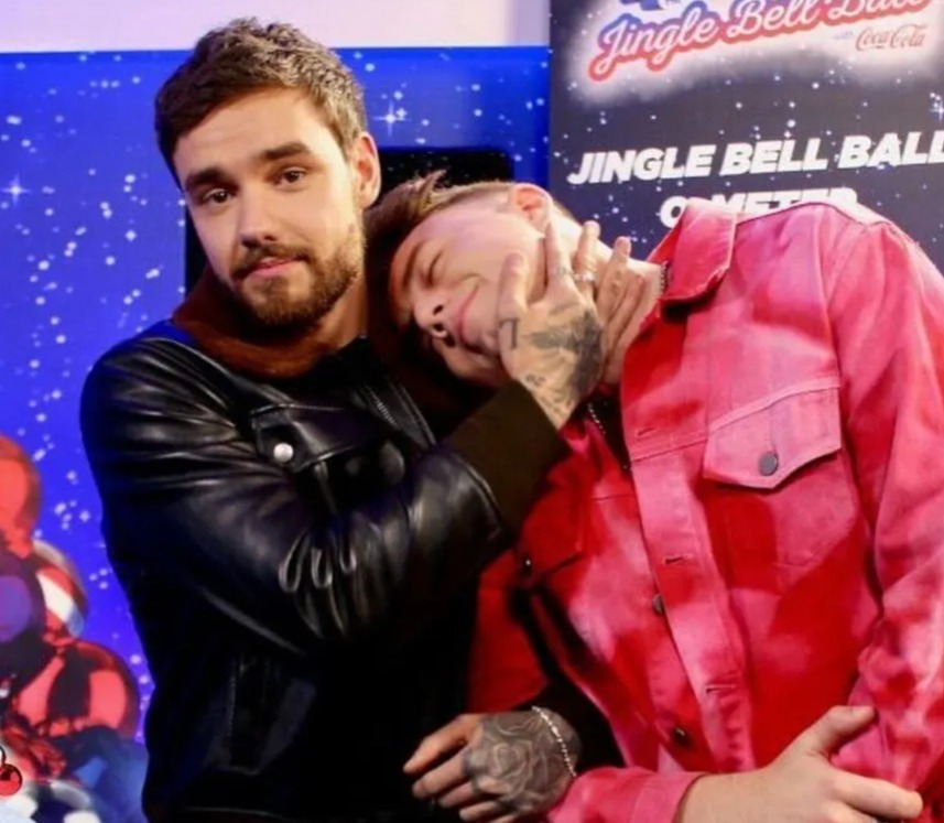 a picture of two men next to a sign that says jingle bell ball