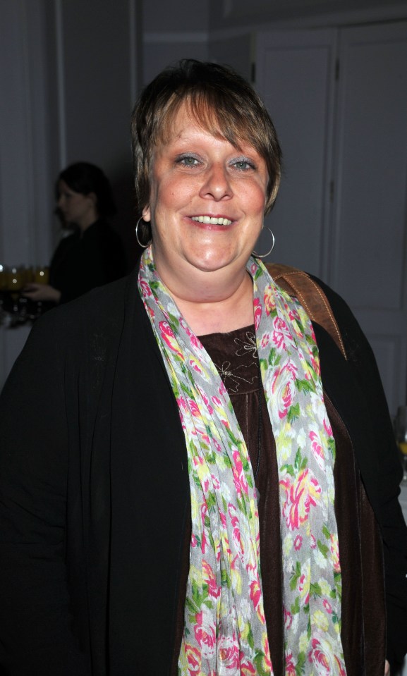 a woman wearing a floral scarf smiles for the camera