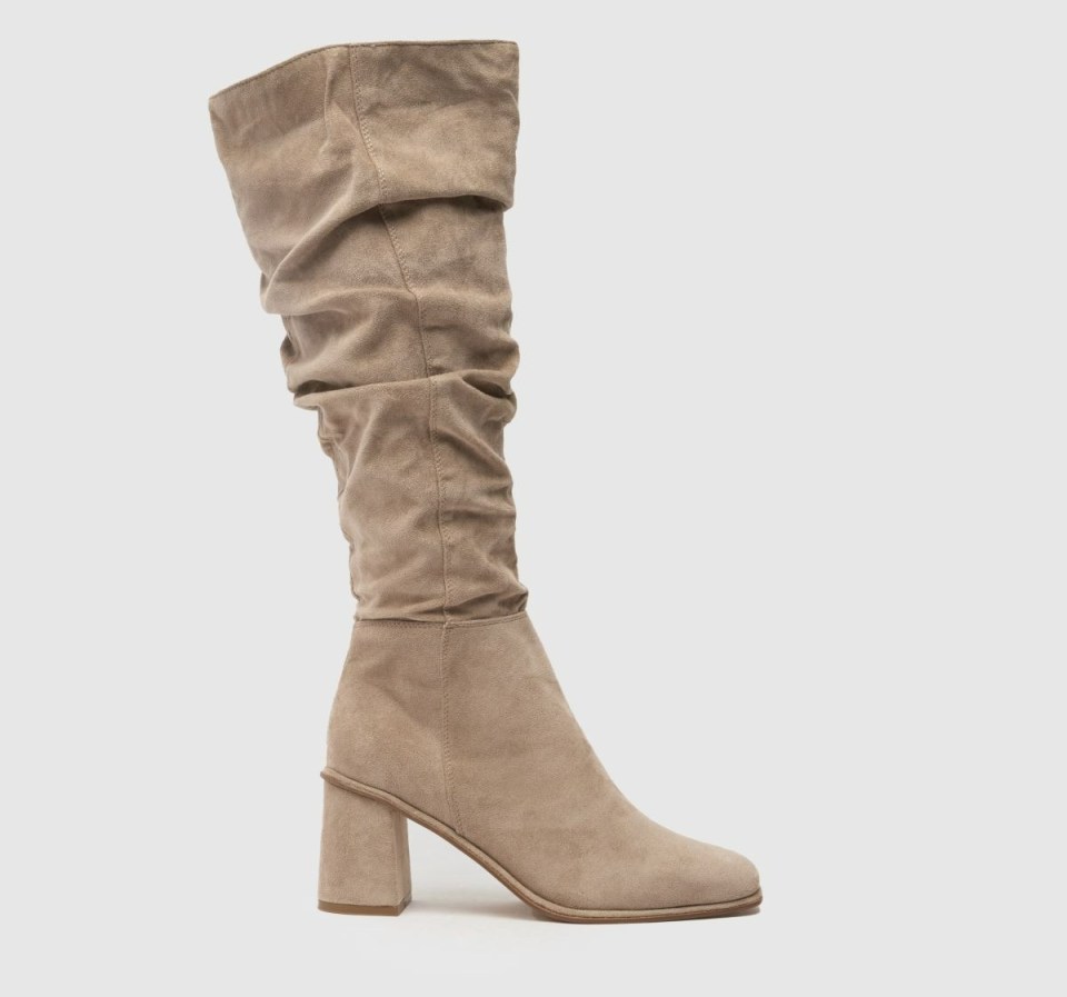 a pair of tan knee high boots with a block heel