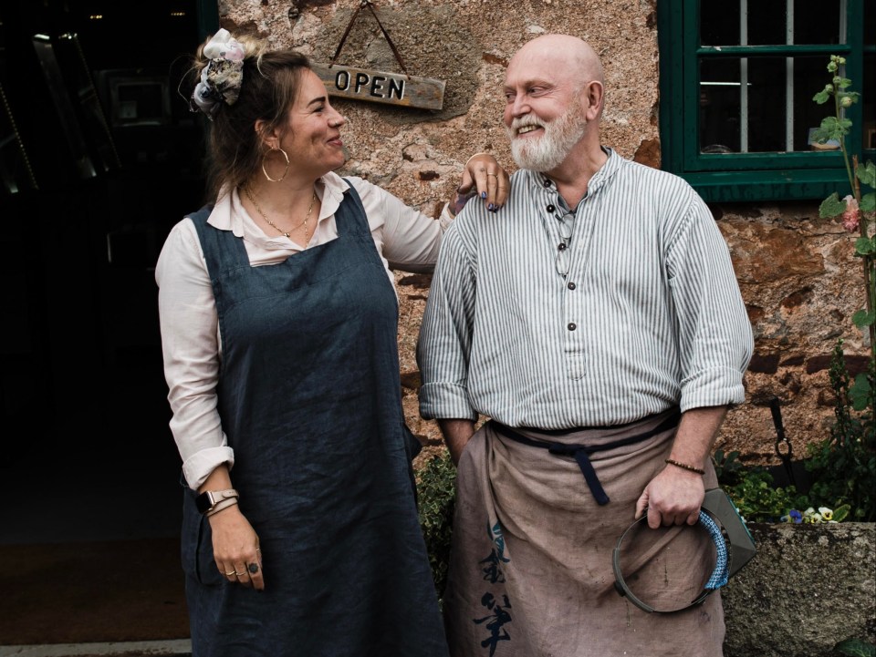 a man and woman standing in front of an open sign