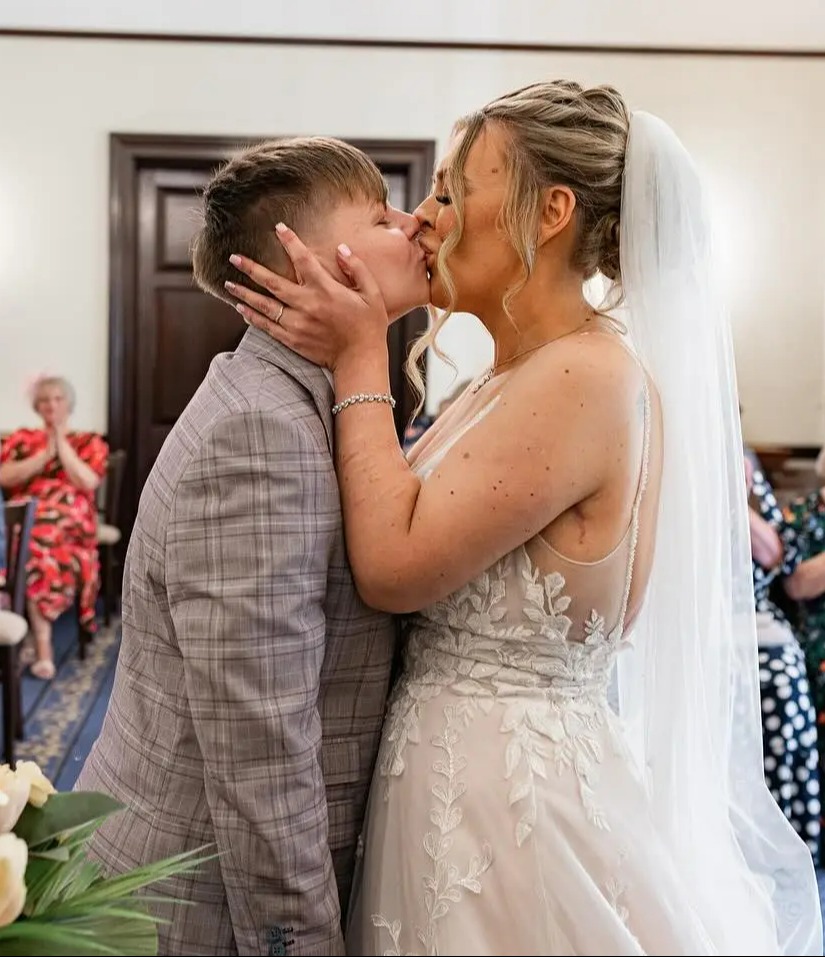 a bride and groom kiss during their wedding ceremony