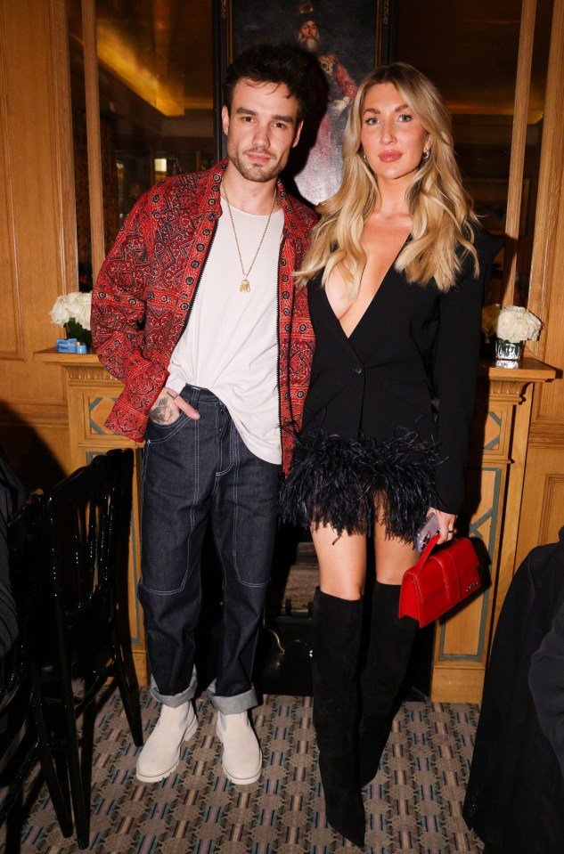 a man and a woman pose for a picture in front of a fireplace