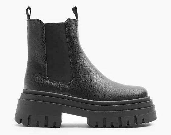 a pair of black chelsea boots with a chunky sole on a white background .