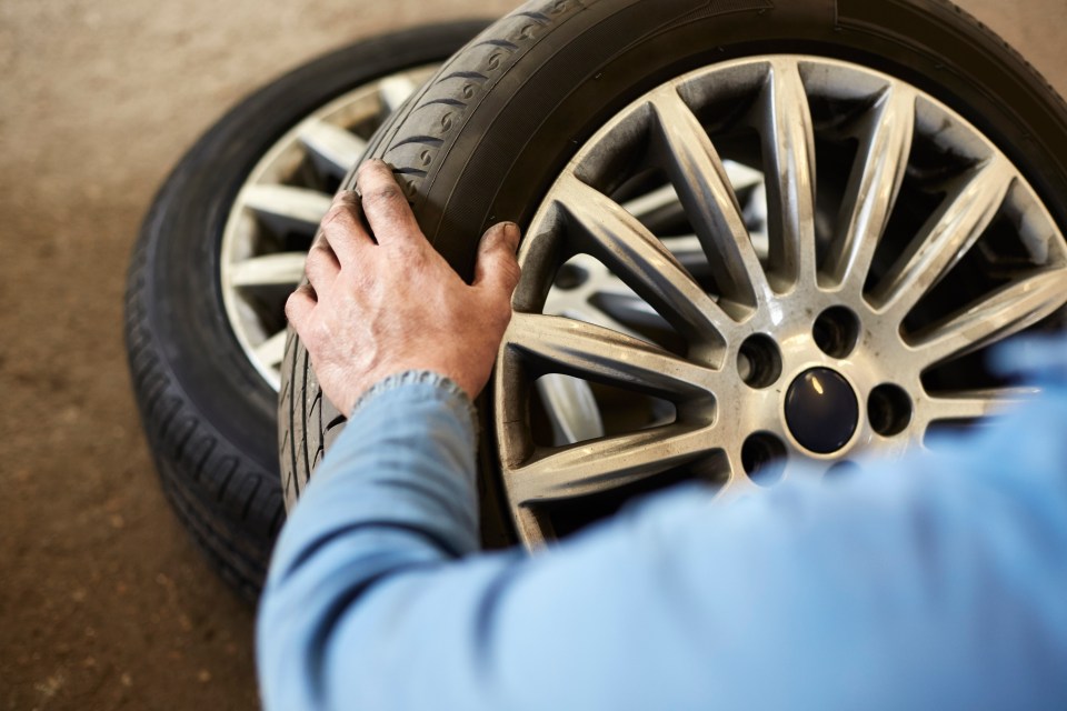 Man holds car tyre