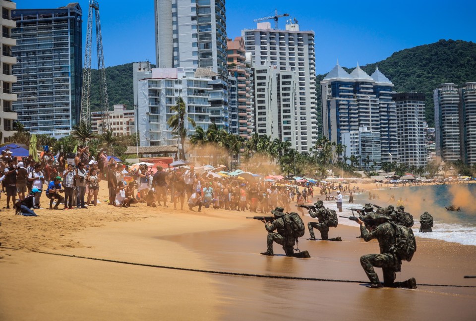 Members of the Mexican Navy participate in an amphibious rescue practice as tourists watch on in horror