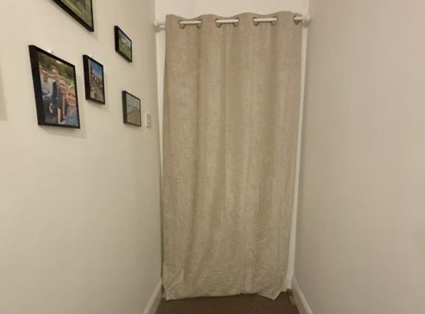 a hallway with pictures on the wall and a curtain