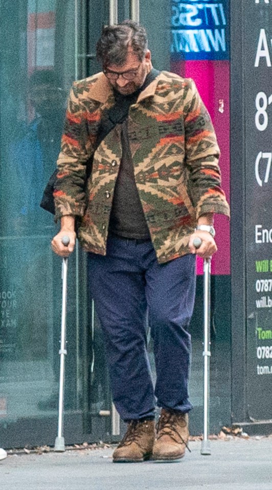 a man walking with crutches in front of a sign that says a on it