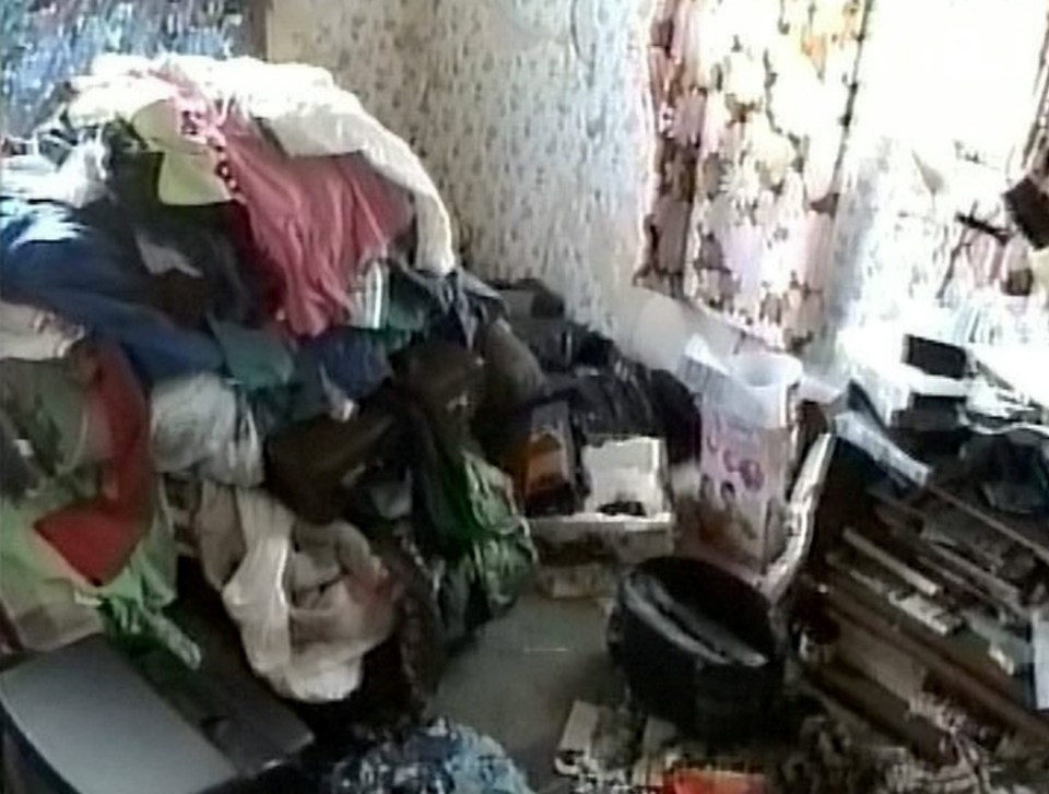 a messy bedroom with a bed , desk , and television .