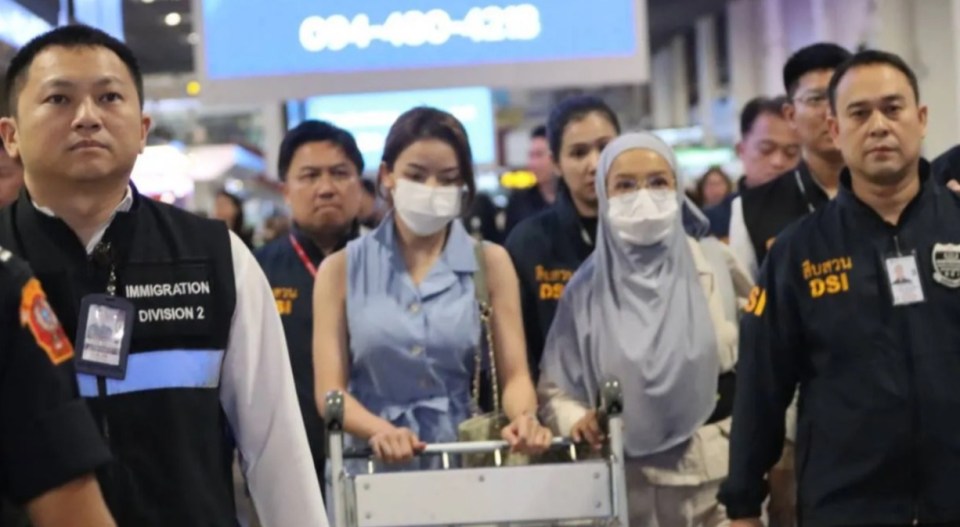 a group of people wearing masks are walking in front of a sign that says immigration division 2