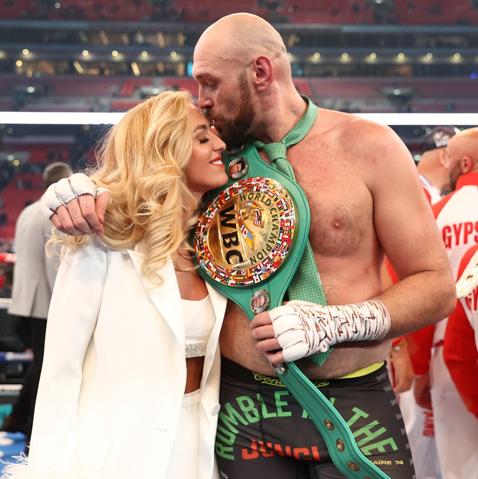 a man kisses a woman on the cheek while wearing a wbc belt