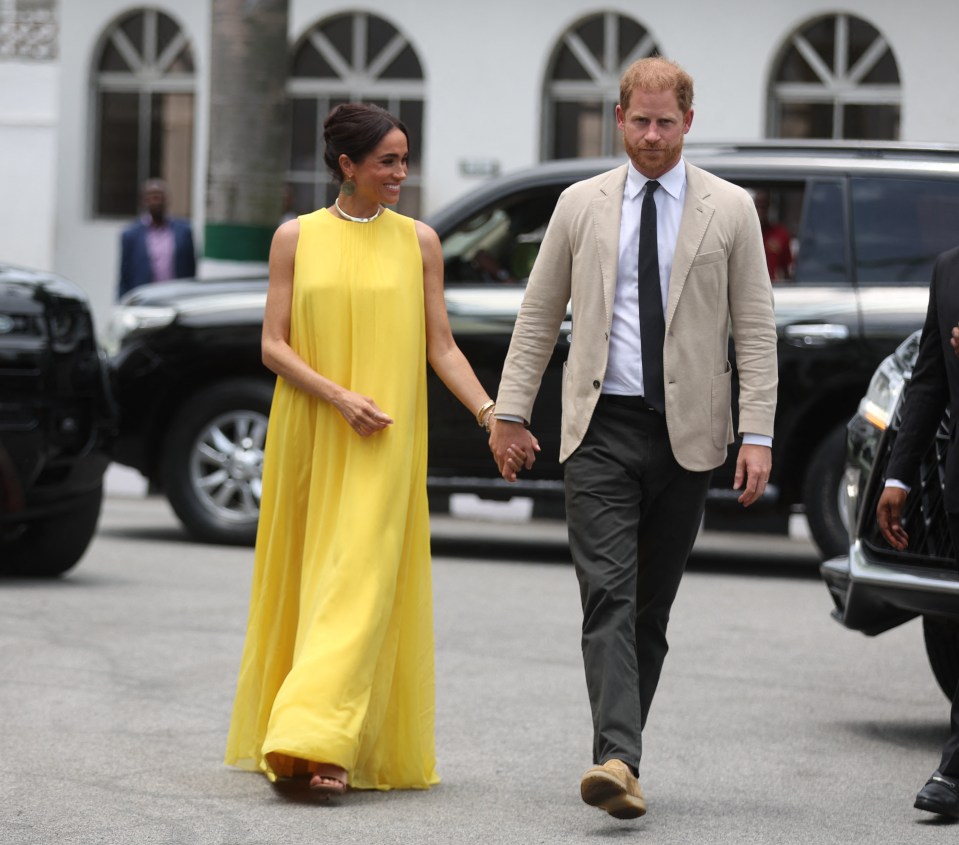 Harry's expression betrays him in May, as Meghan beams brightly