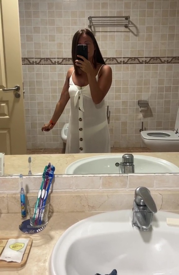 a woman taking a picture of herself in a bathroom mirror