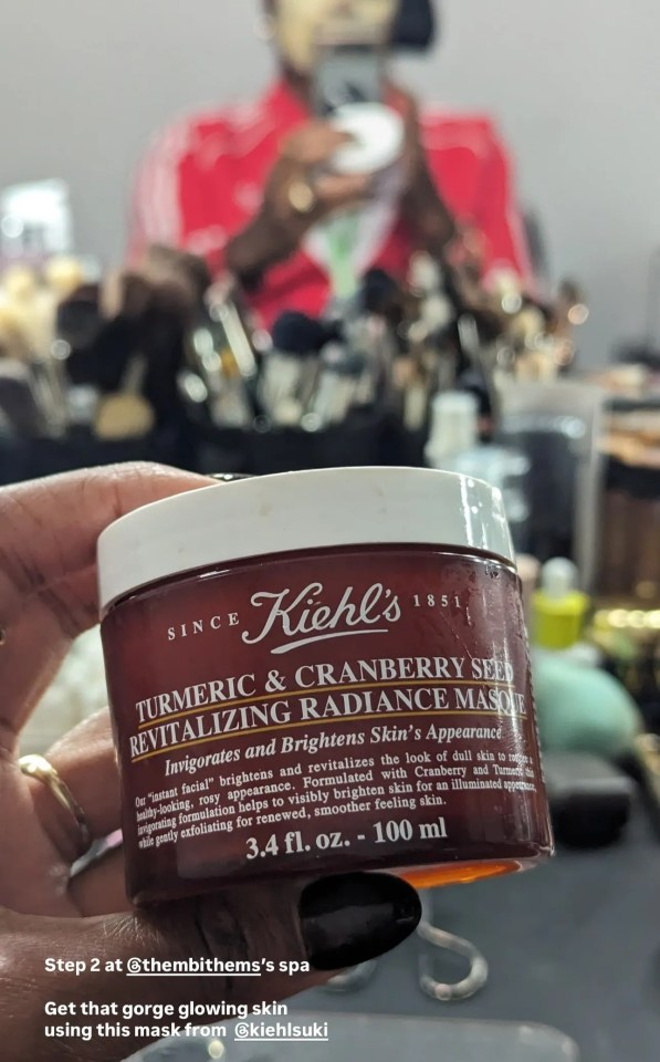 a person is holding a jar of kiehl 's turmeric and cranberry seed revitalizing radiance mask