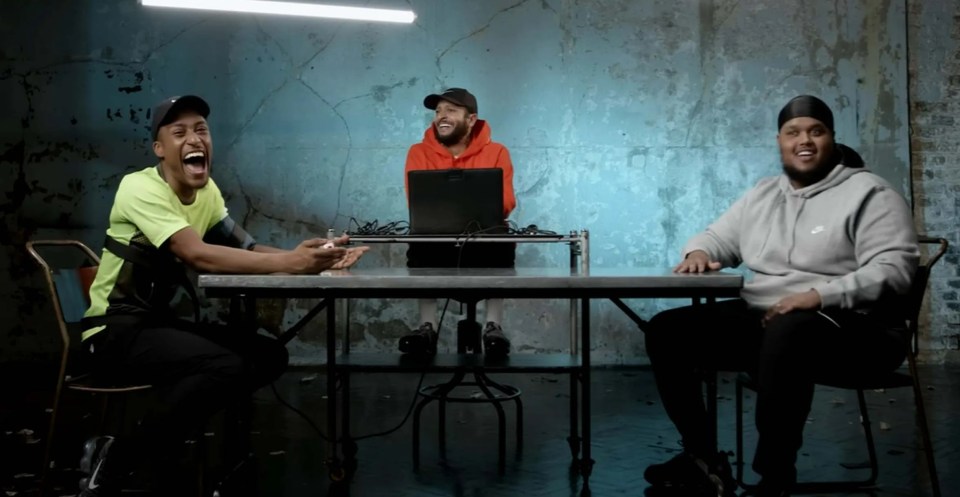 three men sit at a table in front of a sign that says foota2lum