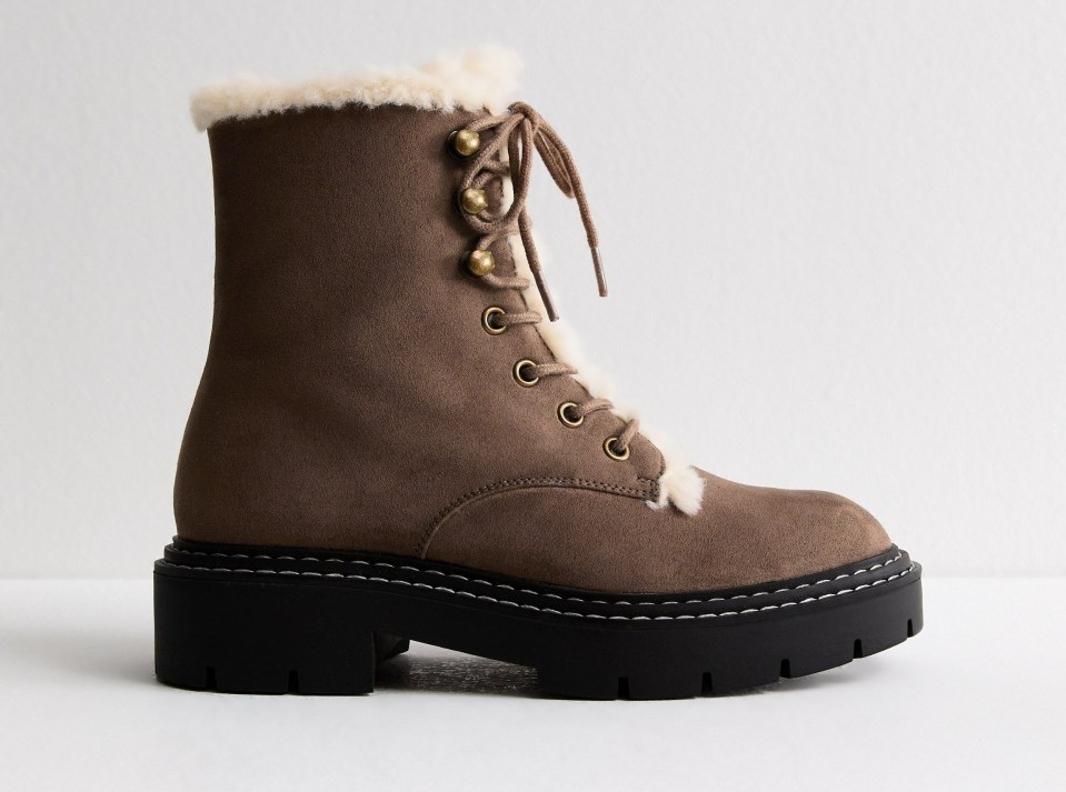 a pair of brown lace up boots with a black sole