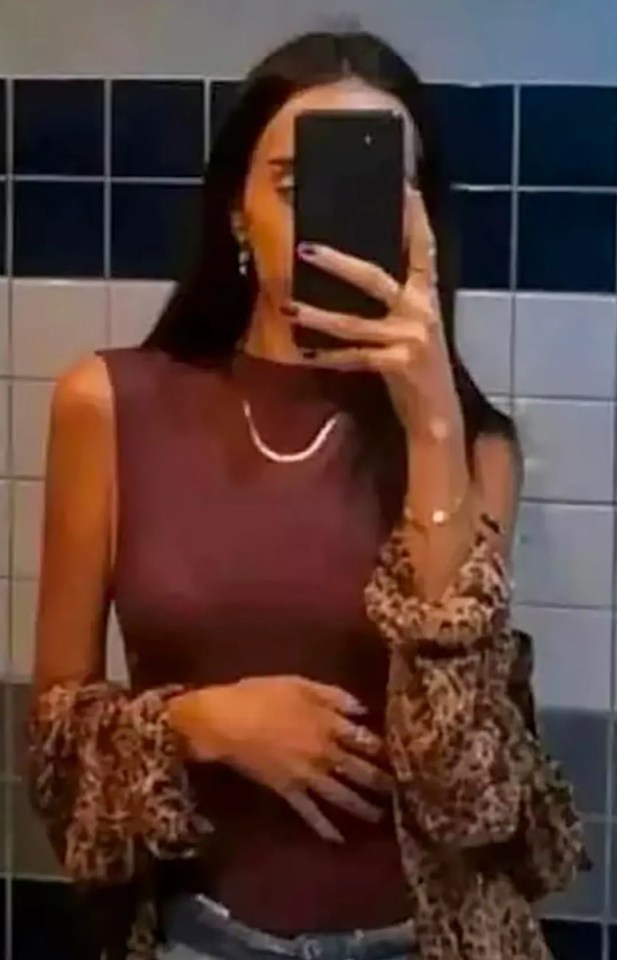 a woman is taking a selfie in a bathroom mirror .